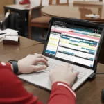 An AD works on his laptop at his desk, avoiding Athletic Director burnout.