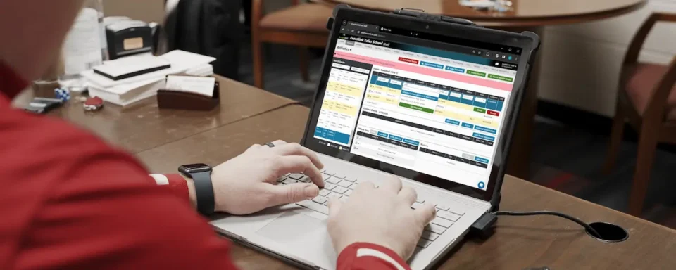 An AD works on his laptop at his desk, avoiding Athletic Director burnout.