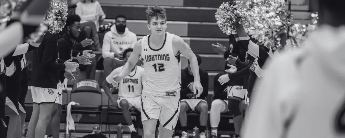 Young man runs out to the court for a basketball game.