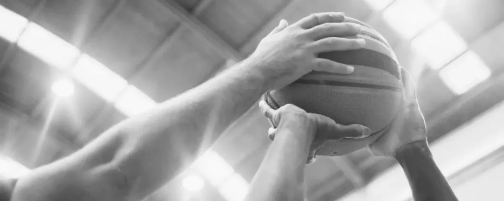Basketball player has his shot blocked by an opposing player. 