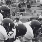 Group of students playing a high school football game.