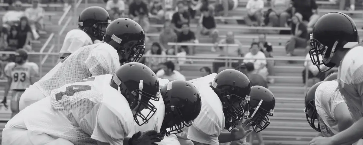 Group of students playing a high school football game.