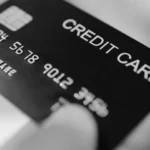 Image of a credit card being handed over for transactional purposes.