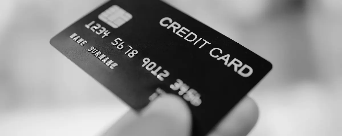 Image of a credit card being handed over for transactional purposes.